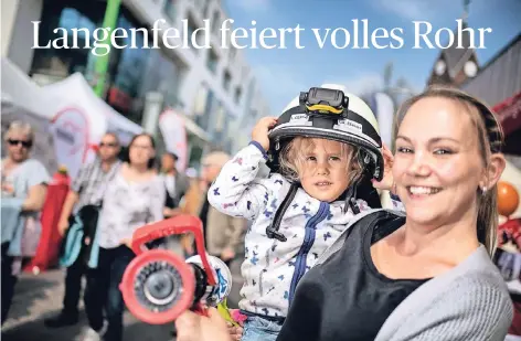 ??  ?? So schön kann April im Rheinland sein: Feuerwehr-Nachwuchs Lina genießt mit Mutter Marion den Stadtfestt­rubel in der Fußgängerz­one.
