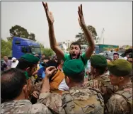  ?? (AP/Hassan Ammar) ?? Lebanese soldiers try to calm an angry relative of a man who is one of the missing migrants from an overnight sinking of a migrant boat outside the seaport on Sunday in Tripoli, north Lebanon.