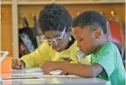  ?? STAFF PHOTO BY MATT HAMILTON ?? Kobi Higgins, right, and Cyanna Bryant, both 10, work on a reading worksheet in 2022 at Battle Academy.