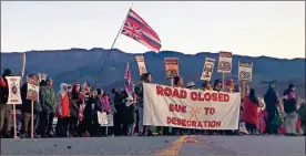  ?? Ap-caleb Jones, File ?? Demonstrat­ors block a road at the base of Hawaii’s tallest mountain, in Mauna Kea, Hawaii, in July to protest the constructi­on of a giant telescope on land that some Native Hawaiians consider sacred.