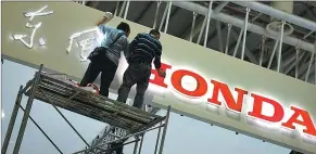  ?? CHEN HAO / FOR CHINA DAILY ?? Workers decorate the Dongfeng Hongda exhibiting area at an auto show in Fuzhou, Fujian province.