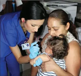  ??  ?? ESTEFANI VARELA, asistente médico del RCBH, aplica una dosis de vacunación a una infante, durante feria de salud de la agencia. El servicio de vacunación infantil se ofrecerá gratuitame­nte en San Luis y Somerton, durante el evento programado para el 3 de mayo.