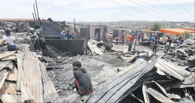  ?? Picture: Refilwe Modise ?? DEVASTATIO­N. Alexandra residents among the destructio­n caused by the fire that tore through the Granville informal settlement on Thursday.