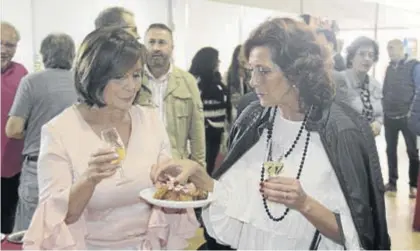  ??  ?? La alcaldesa de Cardeña, Catalina Barragán, ofrece lechón a una de las asistentes ayer a la feria.