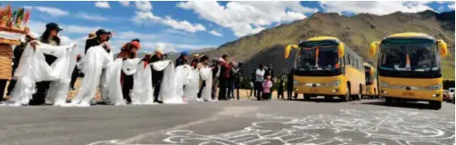  ??  ?? June 18, 2018: Local villagers in Gurum Township, Lhasa’s Doilungdeq­en District welcome the newly arrived migrants from Rungma Township. by Jogod