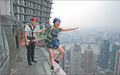  ?? GAO ERQIANG / CHINA DAILY ?? A tourist takes a skywalk at a barrier-free access, which is 340 meters above the ground, at the Jin Mao Tower, an 88-story skyscraper in Shanghai.