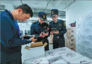  ?? XU YU / XINHUA ?? Customs officials check imported wines in Lishui, Zhejiang province.