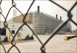  ?? Al Seib Los Angeles Times ?? PORTIONS of the closed plant are wrapped in scaffoldin­g. The facility has been blamed for spreading lead dust over homes, yards, schools and parks for decades.