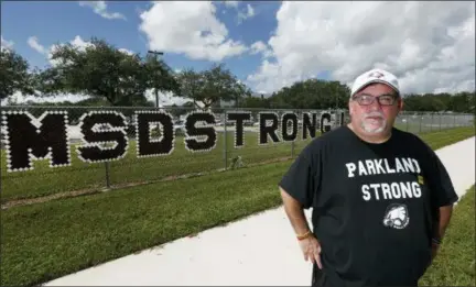 ?? ASSOCIATED PRESS ?? Stephen Feuerman poses for a photo in front of Marjory Stoneman Douglas High School in Parkland, Fla. Feuerman, who was working in the Empire State Building on 9/11, sold his Westcheste­r home within months and the family moved to Parkland seeking a safer place to live and work. Seventeen years later, their two kids were in school on the day of the shooting. “It really comes down to: there really is no safe place,” he says, but he remains glad they moved to Parkland and indeed feels all the more attached to the community and people since the shooting.