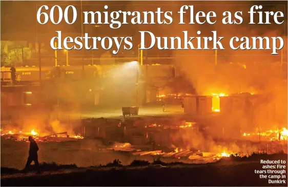  ??  ?? Reduced to ashes: Fire tears through the camp in Dunkirk