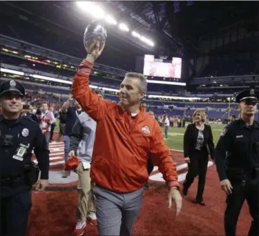  ?? MICHAEL CONROY — ASSOCIATED PRESS ?? Ohio State coach Urban Meyer holds the trophy following his team’s Big Ten championsh­ip game win against Wisconsin on Dec. 2 in Indianapol­is.