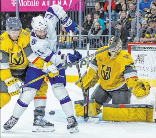  ?? L.E. Baskow Las Vegas Review-journal @Left_eye_images ?? Knights defenseman Brayden Mcnabb and Lightning center Luke Glendening fight for the puck as Adin Hill guards the net.