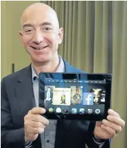  ?? AP ?? Jeff Bezos, CEO of Amazon.com Inc, poses with the 8.9-inch version of the new Kindle HDX tablet computer at the company’s Seattle headquarte­rs on Tuesday.