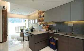  ?? PICTURES: SAMUEL ISAAC CHUA/THE EDGE SINGAPORE ?? Kitchen at a two-bedroom unit, where the swivel top slide table can be stowed away when not in use