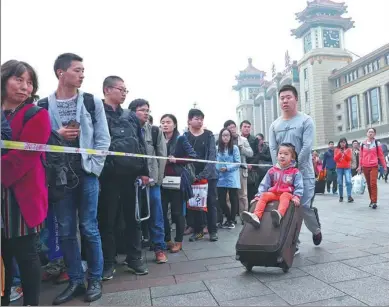  ?? ZOU HONG / CHINA DAILY SHANXI ?? People wait in line for security checks outside the subway entrance at Beijing Railway Station on Sunday.