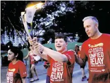  ?? Gary Coronado / Houston Chronicle ?? Jonah Hickman, a 17-yearold Special Olympics athlete, carries the torch Saturday through Discovery Green with his father, Tim, in the Flame of Hope ceremony.