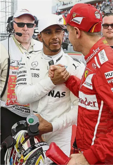  ??  ?? Catch me if you can: Mercedes’ Lewis Hamilton (left) is congratula­ted by Ferrari’s Sebastian Vettel after winning pole position for the US Grand Prix at the Circuit of the Americas on Saturday. — AP
