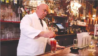  ??  ?? A bartender at Harry's New York Bar in Paris, right, mixes up a bloody Mary. The cocktail is said to have been created at the bar, an institutio­n since 1911.