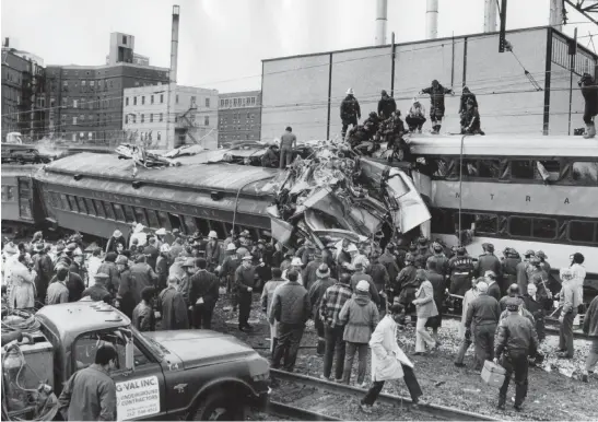  ?? WILLIAM YATES/CHICAGO TRIBUNE ?? Firefighte­rs work at the scene of the wreckage after an Illinois Central electric train backed up after missing the stop the 27th Street Station and collided with the train behind it on Oct. 30, 1972, in Chicago. The crash killed 45 and injured more than 300.
