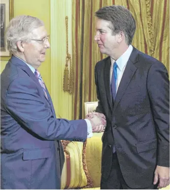  ?? MANDEL NGAN/AFP/GETTY IMAGES ?? Senate Majority Leader Mitch McConnell, R-Ky., shakes hands with Supreme Court associate justice nominee Brett Kavanaugh in McConnell’s office at the Capitol on Tuesday.