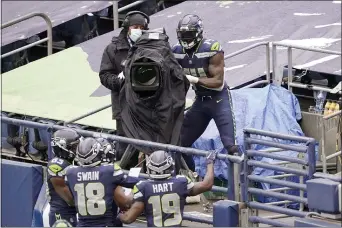  ?? TED S. WARREN — THE ASSOCIATED PRESS ?? Seattle Seahawks wide receiver DK Metcalf (14) briefly takes over a broadcast camera to point at his teammates after climbing into the stands after he scored a touchdown against the Jets.