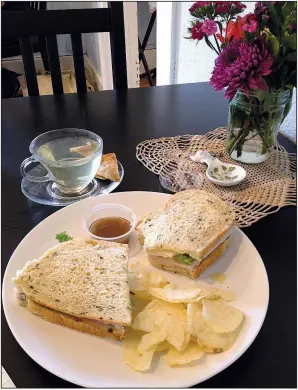  ?? Arkansas Democrat-Gazette/JENNIFER NIXON ?? Sandwiches, like this roast turkey on spinach feta bread from Old Mill Bread served with Cherry Green Tea, make a hearty lunch at Abbi’s Teas &amp; Things, a new tea shop in Hillcrest.