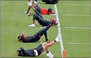  ?? AP-John Bazemore ?? Atlanta Falcon players stretch during a strength and conditioni­ng NFL football workout on Monday.