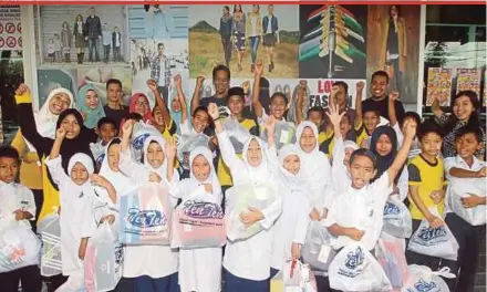  ?? PIC BY FARIZUL
HAFIZ AWANG ?? Pupils of SK Cherating, Kuantan, with school items sponsored by Media Prima Bhd’s Education Assistance programme at Gedung Ten Ten yesterday. With them are Media Prima staff.