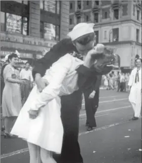  ?? VICTOR JORGENSEN — U.S. NAVY, FILE ?? In this file photo provided by the U.S. Navy, a sailor and a woman kiss in New York’s Times Square, as people celebrate the end of World War II. The ecstatic sailor shown kissing a woman in Times Square celebratin­g the end of World War II has died. George Mendonsa was 95. It was years after the photo was taken that Mendonsa and Greta Zimmer Friedman, a dental assistant in a nurse’s uniform, were confirmed to be the couple.