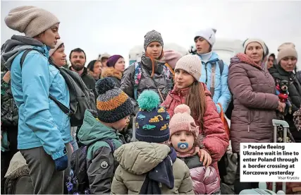  ?? Visar Kryeziu ?? > People fleeing Ukraine wait in line to enter Poland through a border crossing at Korczowa yesterday