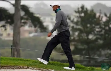  ?? AP Photo/Jeff Chiu ?? Tiger Woods walks along a green during practice for the PGA Championsh­ip golf tournament at TPC Harding Park in San Francisco, on Tuesday.