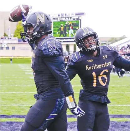  ?? | AP ?? NU’s AnthonyWal­ker celebrates with Godwin Igwebuike (16) after returning a fumble for a touchdown in the fourth quarter.