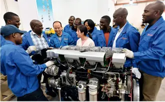  ??  ?? Le 9 octobre 2019, à la base de formation technique des poids lourds de l’École de technique automobile de Shaanxi Automobile à Xi’an. Chen Lilong, professeur­e de technique automobile appliquée, enseigne à des étudiants zambiens.