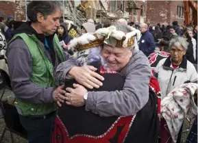  ??  ?? Survivors of St. Michael’s Residentia­l School in Alert Bay on Vancouver Island hug on February 18, 2015, after a symbolic demolition of the former residentia­l school.