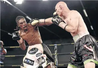  ?? /NICK LOURENS ?? Thulani Mbenge exchanges blows with Shaun Ness in a fight which Mbenge won by a seventh round stoppage to be crowned the new SA welterweig­ht champion at Emperors Palace on Sunday.