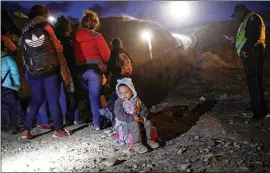  ?? MARIO TAMA / GETTY IMAGES ?? A group of Honduran migrants, including children, who said they were part of the “migrant caravan,” are briefly detained along the U.S.-Mexico border barrier by Mexican police Dec. 1 after an unsuccessf­ul attempt to cross.