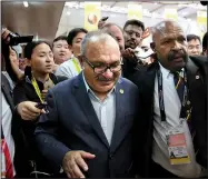  ?? AP/AARON FAVILA ?? Papua New Guinea Prime Minister Peter O’Neill is escorted by security Sunday as he is chased by reporters after reading a statement at the end of the APEC 2018 summit at Port Moresby, Papua New Guinea.