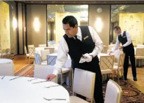  ??  ?? Left: Manuel Guadarrama (front) and Jim Thrailkill prepare a room for a wedding reception at the Loews Regency in S.F.