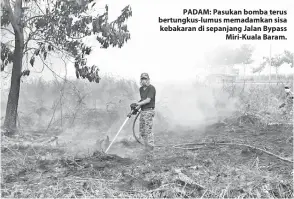  ??  ?? PADAM: Pasukan bomba terus bertungkus-lumus memadamkan sisa kebakaran di sepanjang Jalan Bypass Miri-Kuala Baram.