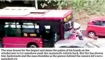  ??  ?? The man braces for the impact and slams the palms of his hands on the windscreen to try somehow push the mammoth vehicle back. But the bus shoves him backwards and the man stumbles as the person behind the camera let’s out a panicked cry