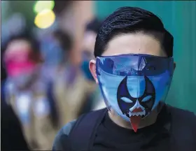  ?? (AP/Fernando Llano) ?? A student wears a face shield over his Lucha Libre wrestling mask Monday as he waits to enter a public school in Mexico City.