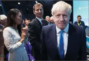  ?? AP/STEFAN ROUSSEAU ?? Boris Johnson walks to the stage Tuesday at the Conservati­ve Party meeting in London after he was announced as the governing party’s leader, meaning he is Britain’s next prime minister. Behind him is Foreign Secretary Jeremy Hunt, his rival for the party’s leadership post.
