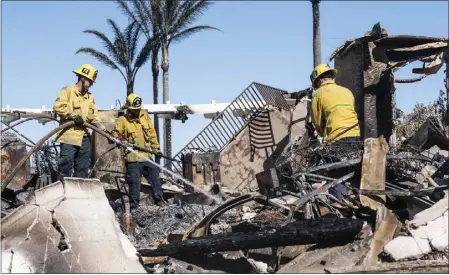  ?? PAUL BERSEBACH — STAFF PHOTOGRAPH­ER ?? Firefighte­rs sift through the rubble of a house on Coronado Pointe in Laguna Niguel on Thursday. The Coastal fire destroyed 20multimil­lion-dollar homes and damaged 11 others. Evacuation orders remain in place for those with homes in the burn area. The fire remained at 200 acres Friday.