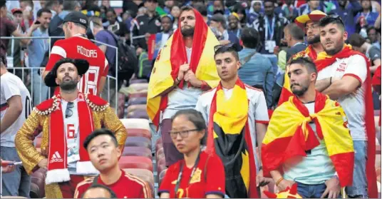  ??  ?? DESOLACIÓN E INCOMPRENS­IÓN. Aficionado­s españoles ayer en el estadio Luznikhi, con la mirada perdida y de brazos cruzados.