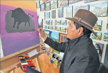  ?? David landeta / el comercio ?? • Alfredo Toaquiza pinta y atiende a los visitantes en su taller ubicado en Tigua.