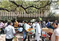  ?? - PTI ?? LONG QUEUE: Food vendors wait for customers as people queue up outside the RBI building in New Delhi to exchange their old banknotes with new ones on Wednesday.