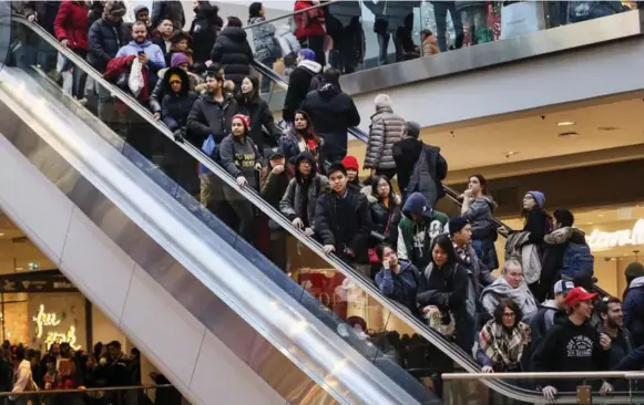  ?? ANDREW FRANCIS WALLACE PHOTOS/TORONTO STAR ?? Shoppers jam the escalators looking for Boxing Day bargains at the Toronto Eaton Centre on Tuesday. “This is my shopping day,” said 73-year-old Annette Farrow of Burnt River, Ont.