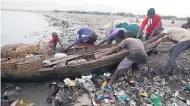  ??  ?? Fishermen remove their wooden boats from the sea as a precaution against Hurricane Irma, in the seaside slum of Port-au-Prince, Haiti.