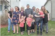  ?? JOSH CLARK/USA TODAY NETWORK-WISCONSIN ?? Becky and Rob Brooks, center, pose for a portrait with their family in front of their home in Manitowoc. From left, Danyell, 17; Isabella, 16; Anna, 4; October, 6; Brian, 6; Cristel, 20; Skylar, 17; Charlie, 3; and their granddaugh­ter Bianca Michel, 13.