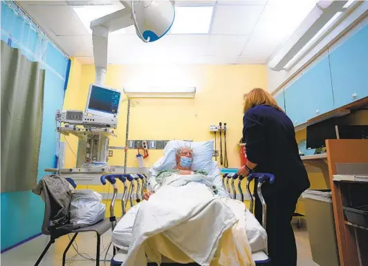  ?? NELVIN C. CEPEDA U-T PHOTOS ?? Michelle Christense­n, an RN assigned as a geriatric emergency medicine specialist at Sharp Grossmont Hospital, gives an assessment evaluation to her patient.